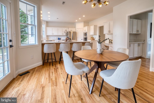 dining room featuring a notable chandelier and light wood-type flooring