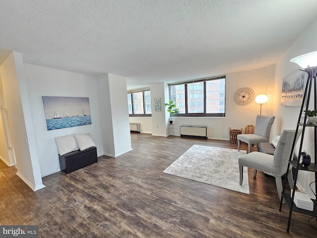 living room with dark hardwood / wood-style floors and a textured ceiling