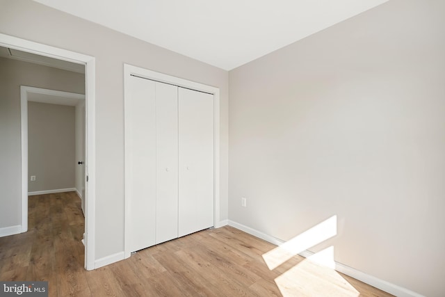 unfurnished bedroom with a closet and light wood-type flooring