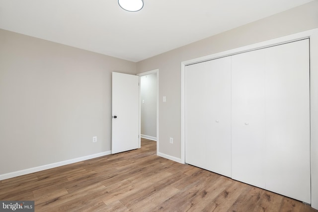 unfurnished bedroom featuring light hardwood / wood-style flooring and a closet