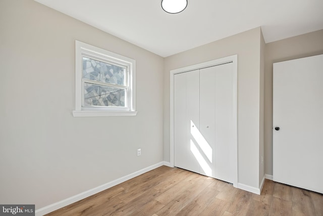 unfurnished bedroom featuring a closet and light hardwood / wood-style flooring