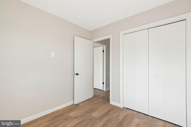 unfurnished bedroom featuring a closet and light wood-type flooring