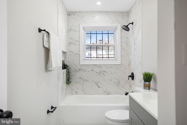 full bathroom with tiled shower / bath, vanity, and toilet