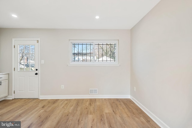 foyer with a wealth of natural light and light hardwood / wood-style flooring