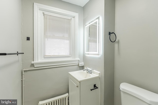 bathroom featuring toilet, vanity, and radiator