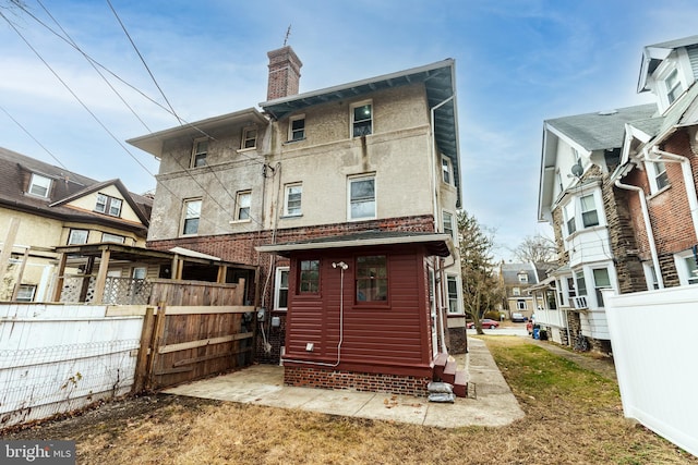 rear view of property with entry steps, a chimney, fence, and cooling unit