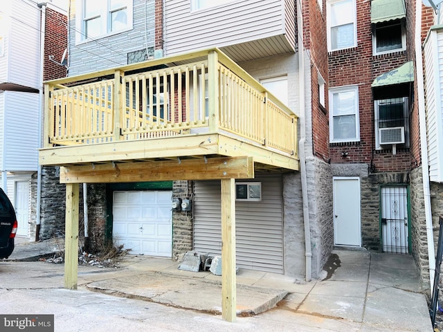 rear view of house featuring a garage and cooling unit