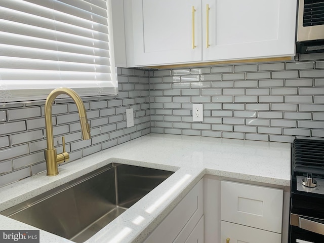 kitchen with white cabinetry, sink, and decorative backsplash