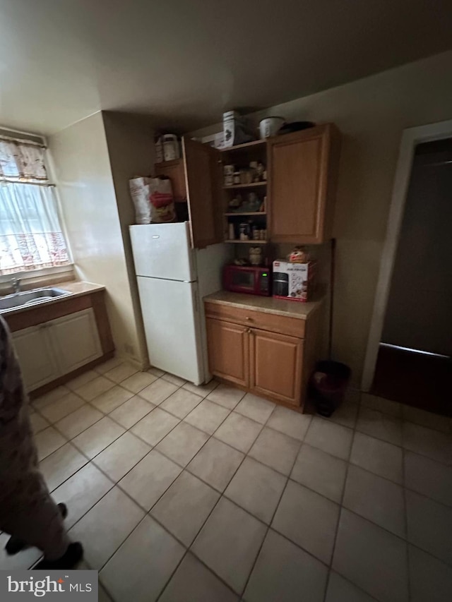 kitchen featuring sink, white fridge, and light tile patterned floors