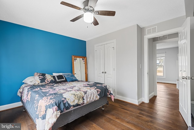 bedroom with a closet, dark hardwood / wood-style floors, and ceiling fan