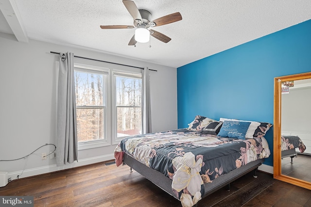 bedroom with a textured ceiling, dark hardwood / wood-style floors, and ceiling fan