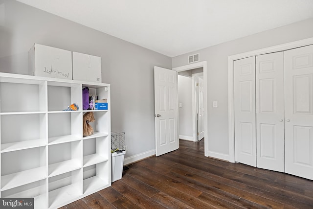 unfurnished bedroom with a closet and dark hardwood / wood-style flooring