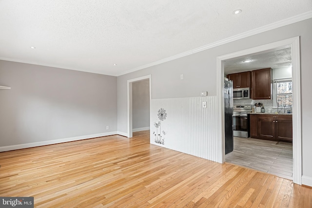 living room featuring light hardwood / wood-style floors, crown molding, and a textured ceiling