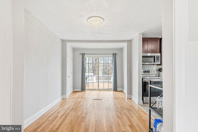 doorway featuring a textured ceiling and light hardwood / wood-style flooring