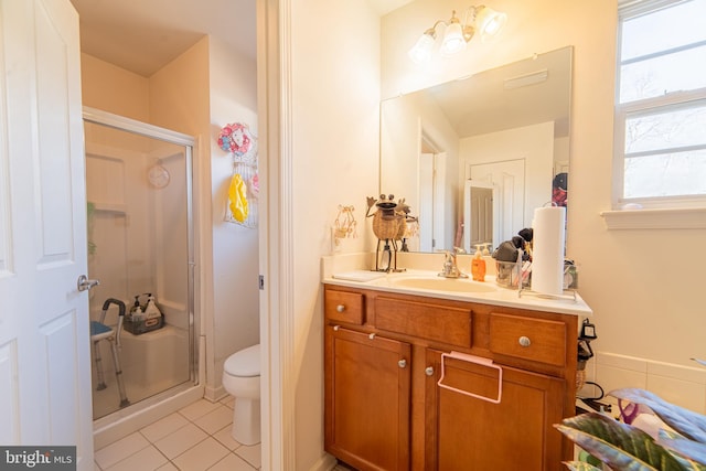 bathroom featuring tile patterned flooring, walk in shower, vanity, and toilet