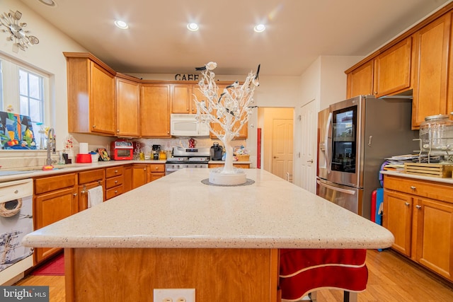 kitchen with a kitchen island, appliances with stainless steel finishes, sink, and decorative backsplash