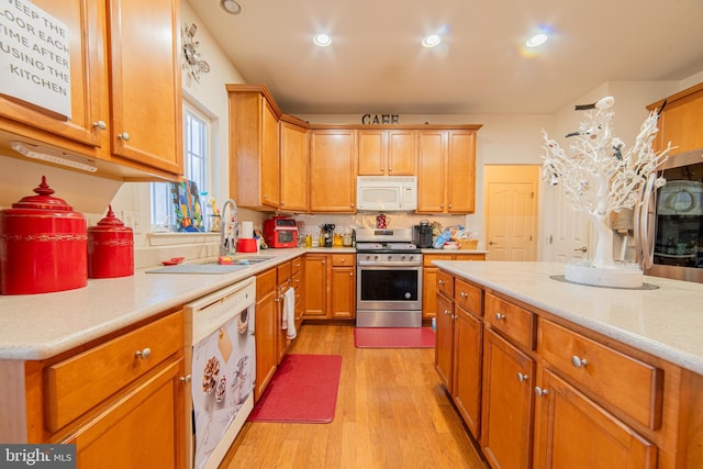 kitchen featuring sink, decorative backsplash, white appliances, and light hardwood / wood-style floors