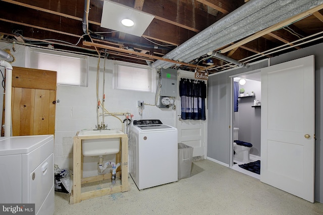 washroom with electric panel, washer and clothes dryer, and sink