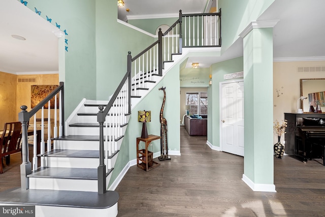 staircase featuring ornamental molding, wood finished floors, visible vents, and baseboards