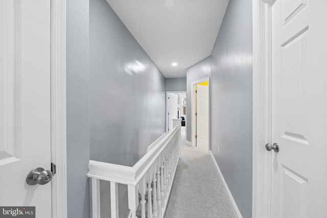 hallway featuring light colored carpet