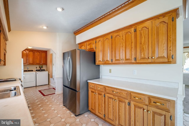 kitchen with stainless steel refrigerator, sink, and washer and dryer