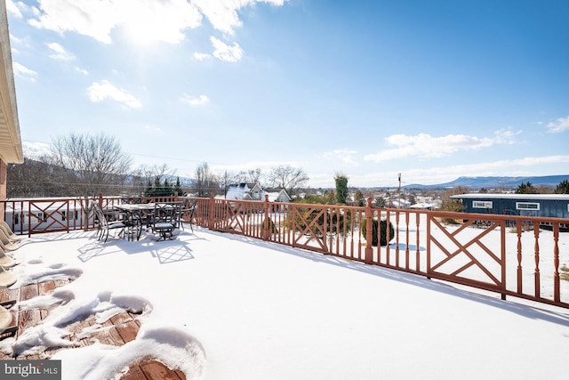 snow covered patio featuring a mountain view