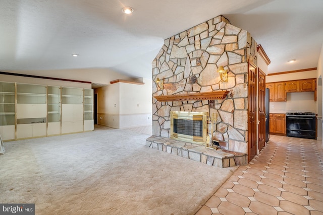 unfurnished living room with crown molding, lofted ceiling, light colored carpet, and a stone fireplace