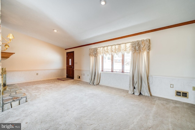 unfurnished living room featuring lofted ceiling, a notable chandelier, crown molding, and carpet flooring