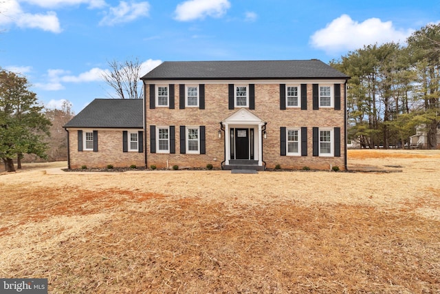 colonial home featuring brick siding