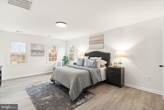 bedroom featuring light wood-type flooring, visible vents, and multiple windows