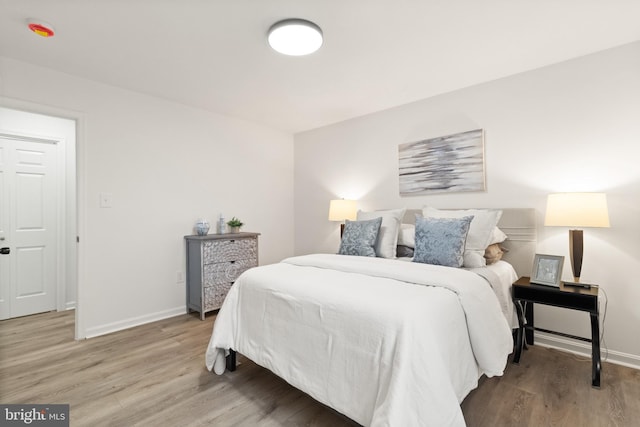 bedroom featuring light wood-style flooring and baseboards