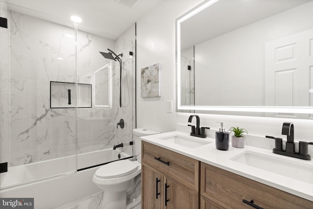 full bath featuring marble finish floor, a sink, toilet, and double vanity