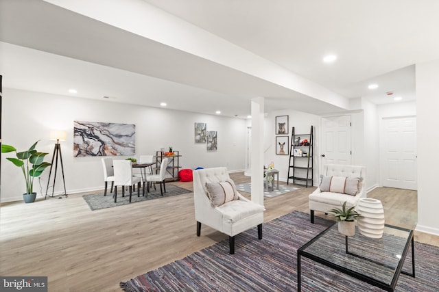 living room featuring baseboards, wood finished floors, and recessed lighting