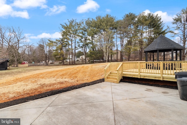 view of patio / terrace with fence, a wooden deck, and a gazebo