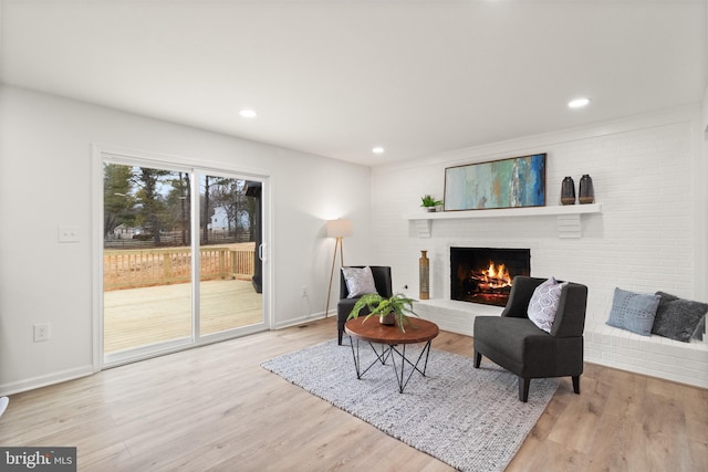 living area with recessed lighting, a fireplace, wood finished floors, and baseboards