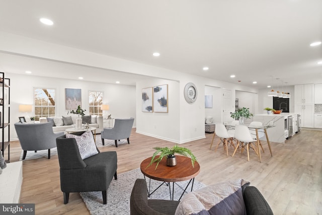 living room featuring baseboards, recessed lighting, and light wood-style floors