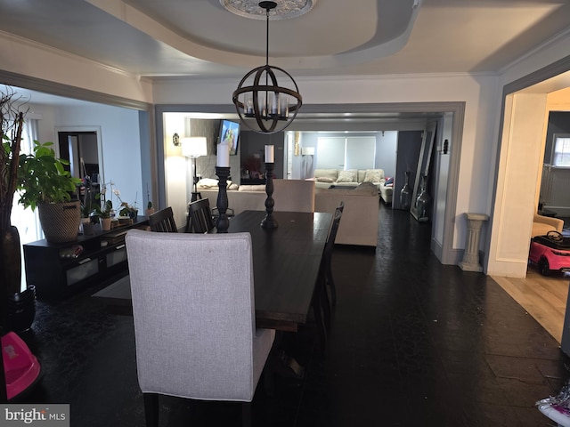 dining room featuring a raised ceiling, ornamental molding, dark hardwood / wood-style floors, and a notable chandelier