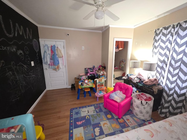 game room with hardwood / wood-style floors, ornamental molding, and ceiling fan