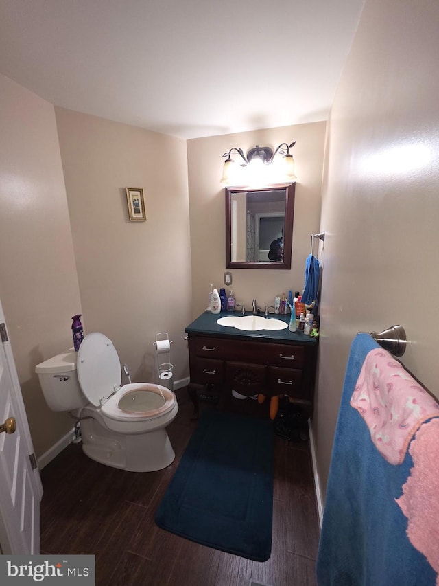 bathroom featuring wood-type flooring, vanity, and toilet