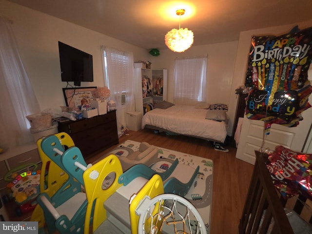 bedroom featuring a chandelier and hardwood / wood-style floors