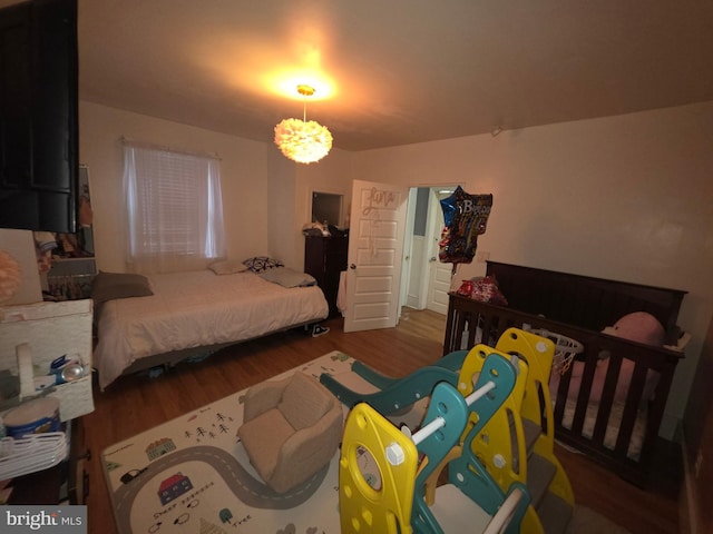 bedroom featuring an inviting chandelier and hardwood / wood-style floors