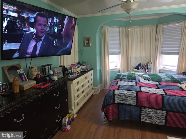 bedroom with crown molding, dark wood-type flooring, and ceiling fan