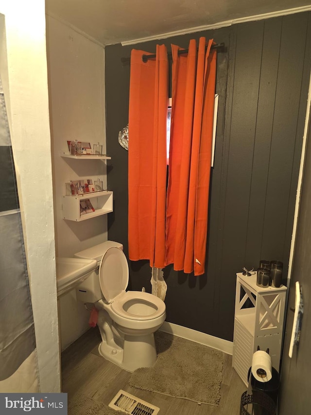 bathroom with wood-type flooring and toilet