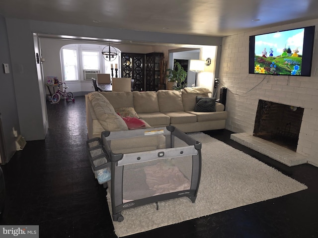 living room with cooling unit and a brick fireplace