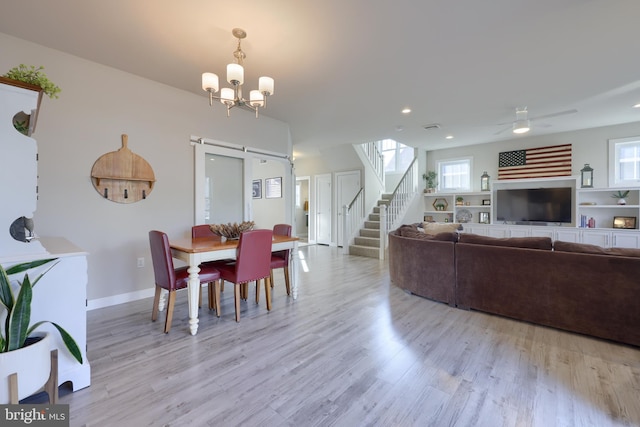 dining area featuring plenty of natural light, a barn door, and light hardwood / wood-style floors