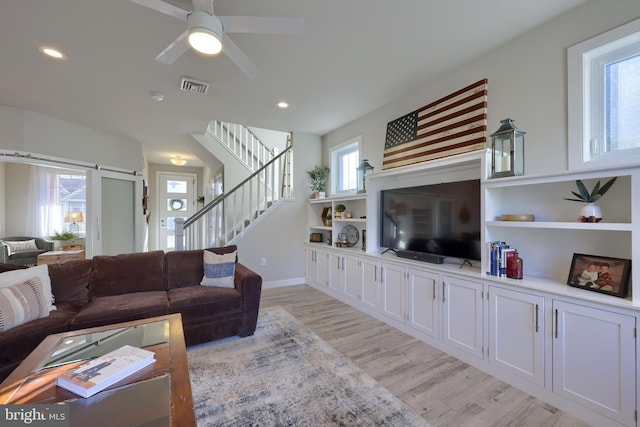 living room featuring ceiling fan and light wood-type flooring