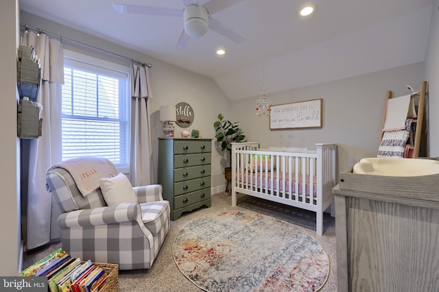 bedroom with vaulted ceiling, a nursery area, and ceiling fan