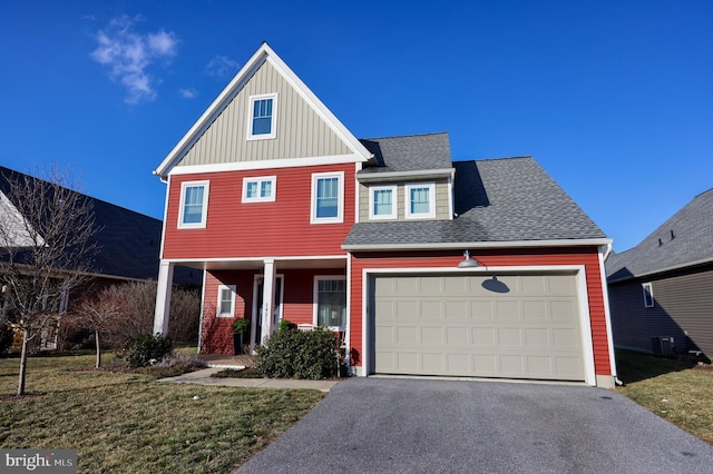 view of front of home with a garage, a front yard, and covered porch