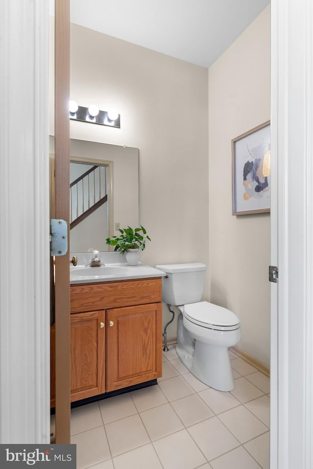 bathroom featuring tile patterned flooring, vanity, and toilet