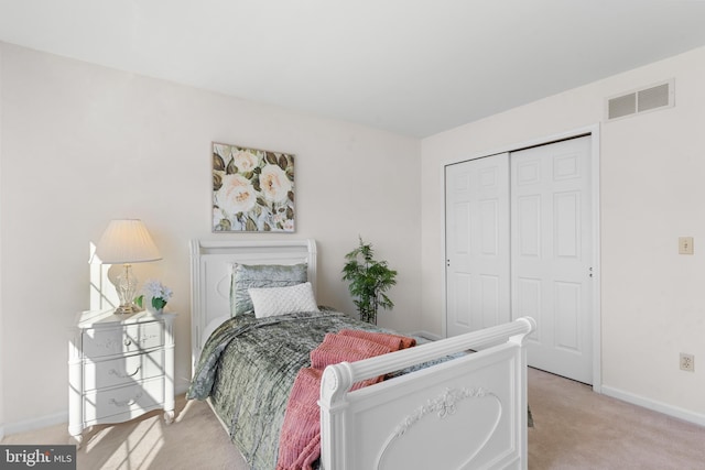 bedroom featuring light colored carpet and a closet